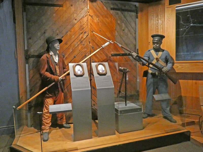 Exhibit showing two Black men holding pikes 