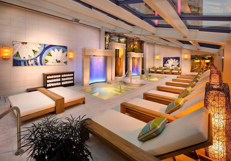 Spa lounge with plunge pools lined with beige lounge chairs in Reno, Nevada. 