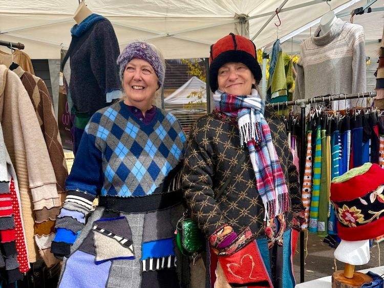 Two women vendors wear  vibrant, upcycled wool clothing at the Happy Trails Festival in Ketchum.