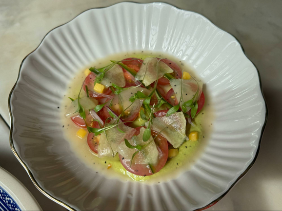 Red tomatoes and corn on a white dish. 